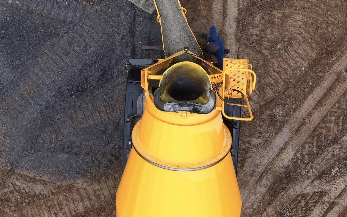 Precast wastewater tank lowered into an excavation during treatment system installation