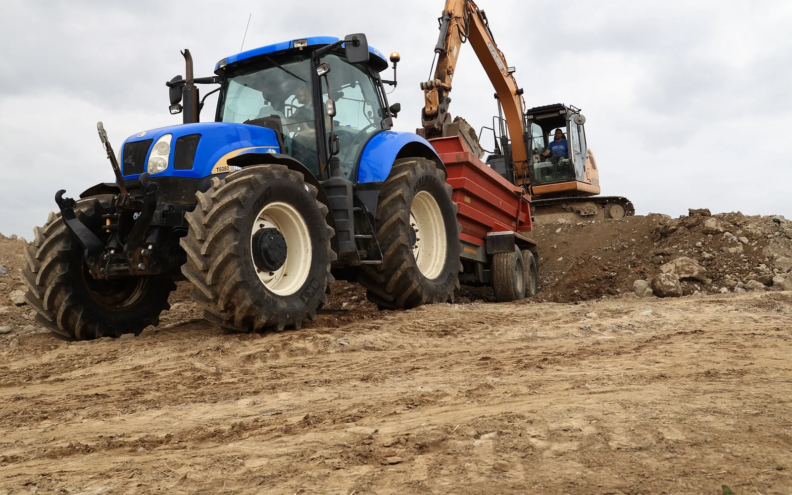 Tractor and excavator moving earth on a groundworks site for Shane Blanche Groundworks, Carlow