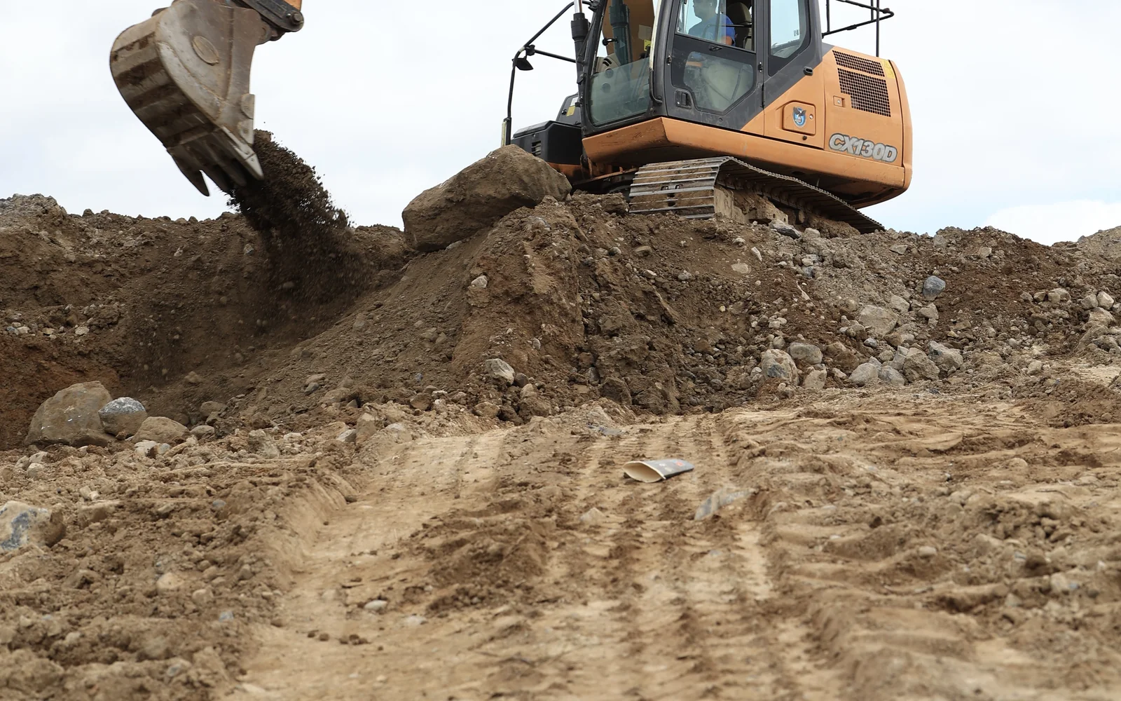 Excavator clearing and grading soil to prepare a construction site in Carlow